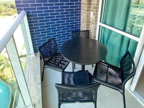 萨利诺波利斯Salinas Exclusive Resort的阳台上配有一张黑色的桌子和椅子