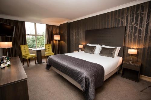 新罗斯布兰之家酒店的酒店客房设有一张大床和一张书桌。