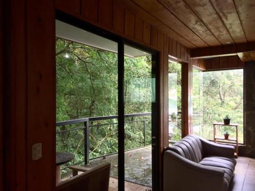蒙泰韦尔德哥斯达黎加Manakin Lodge, Monteverde的门廊上设有沙发和窗户的屏风