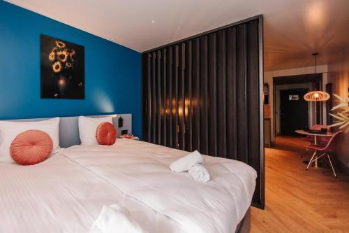 赞德沃特凯乌尔酒店的卧室配有白色大床和蓝色的墙壁