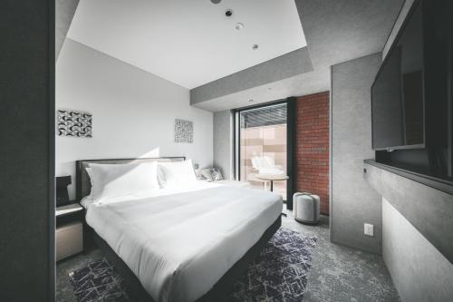 札幌SAPPORO STREAM HOTEL的卧室设有一张白色大床和一扇窗户。