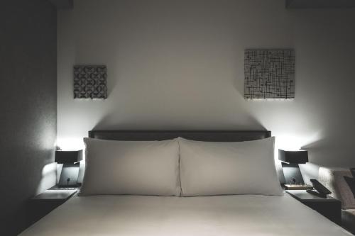 札幌SAPPORO STREAM HOTEL的一间卧室,床上方有两盏灯
