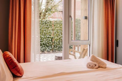 赞德沃特凯乌尔酒店的一间卧室配有一张床和一个带毛巾的窗户