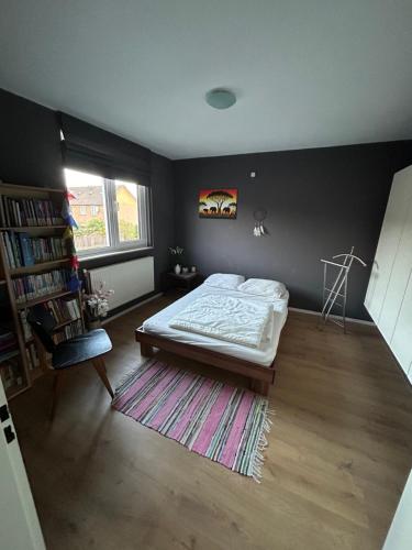 奈梅亨Compleet huis in Nijmegen的一间卧室设有一张床和一个书架