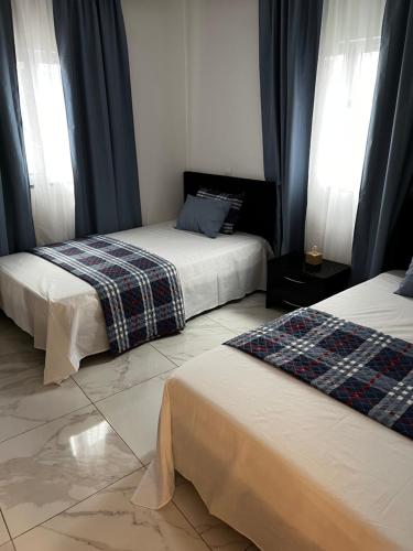 CalhetaPensão Gonçalves的一间卧室设有两张床和两个窗户。