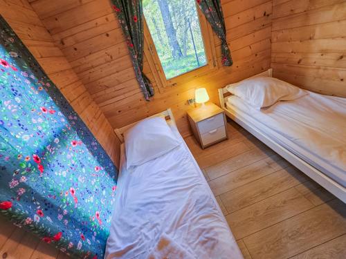 科帕利诺Bursztynowa Osada的小屋内一间卧室的顶部景观,配有两张床