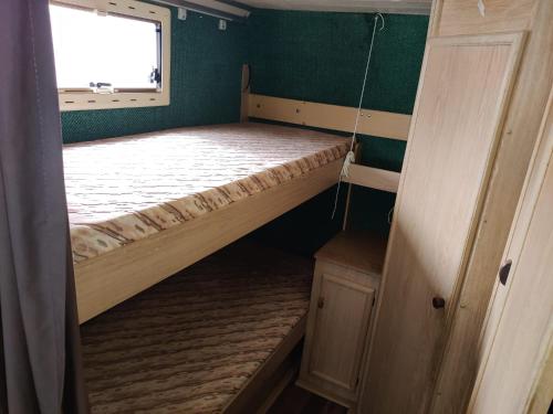 赫尔辛基Helsinki's Caravan Adventureヅ的小房间设有床和窗户