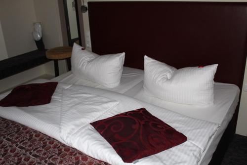 米尔滕贝格Hotel Schmuckkästchen的一张带白色床单和枕头的床