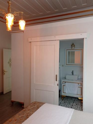 KarşıyakaBUDAKZADE KONAĞI OTEL-RESTAURANT 1841的卧室设有白色门和水槽