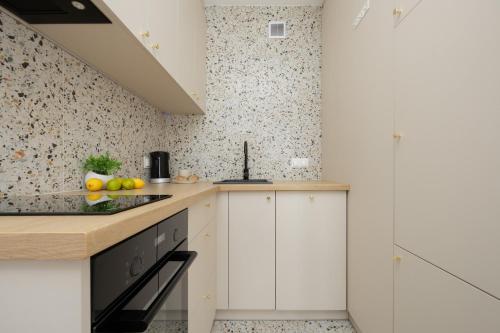 华沙Pereca Stylish Apartment Warsaw & Air Conditioning by Rent like home的厨房配有白色橱柜和花卉壁纸