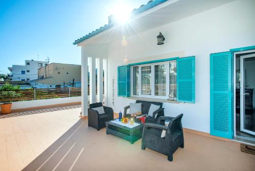 卡拉圣维森特Owl Booking Villa Magdalena - 5 Min Walk to the Beach的庭院设有蓝色百叶窗和桌椅