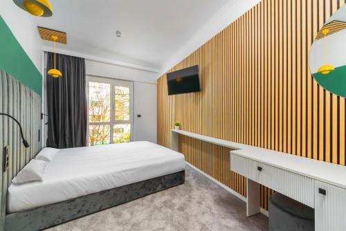 蒂米什瓦拉URBAN BUDGET HOTEL的一间卧室配有一张床、一张书桌和一个窗户。