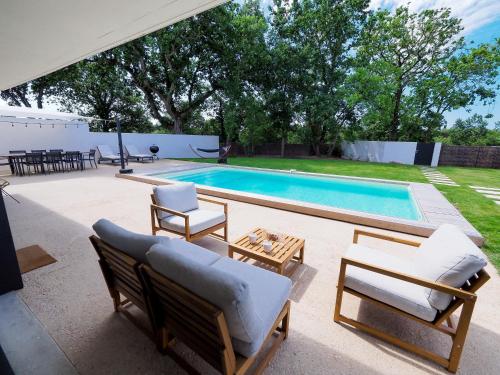 塔勒蒙Beautiful Villa close to the Seaside的一个带椅子的庭院和一个游泳池