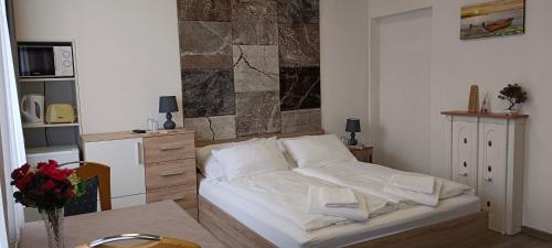 采尔特韦格Ring Gasthaus的卧室配有白色的床和桌子