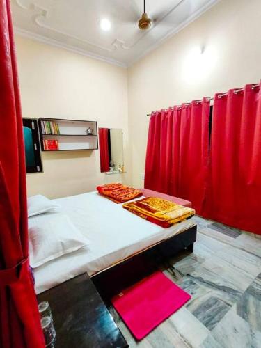 Ayodhya2 Bedroom Suite on Ground Floor Ayodhya的一间卧室配有红色窗帘和一张红色床单