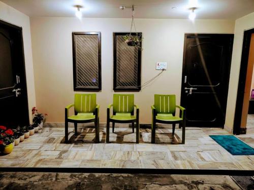 Ayodhya2 Bedroom Suite on Ground Floor Ayodhya的三个绿色椅子坐在候机室