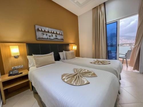 得土安Prestige Hotel & Spa的酒店客房设有两张床和窗户。