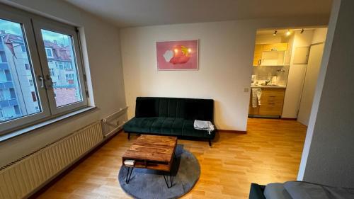 斯图加特Apartment 1 im Lehenviertel的客厅配有绿色沙发和茶几