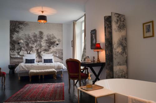 佩里格La Villa Marguerite的一间卧室配有一张床、一张桌子和一张书桌