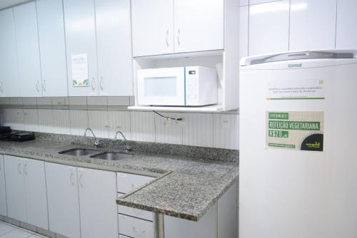 贝洛奥里藏特Br Hostel的白色的厨房配有水槽和微波炉