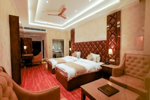 达兰萨拉Grand Him Queen AC Centralized的酒店客房,设有两张床和一张沙发