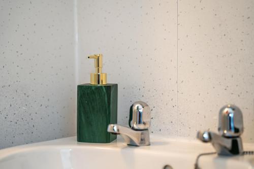 考文垂Cosmopolitan Comforts Flat的浴室水槽设有2个水龙头和镜子