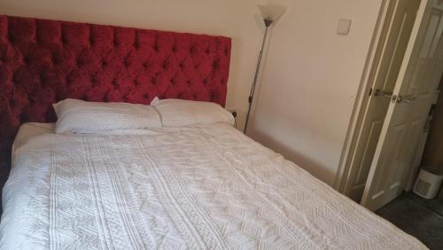 IkuataBeautiful 3-Bed House in Lekki的一张带红色垫子床头板和白色床单的床