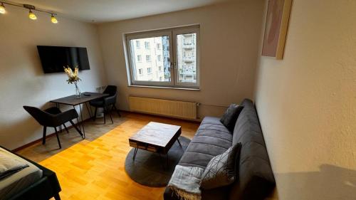 斯图加特Apartment 2 im Lehenviertel的客厅配有沙发和桌子