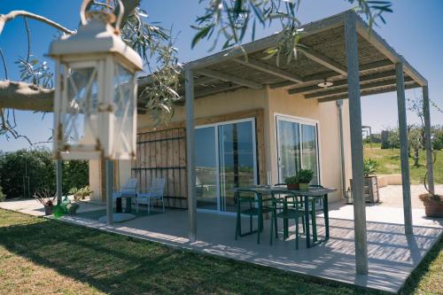 帕基诺NEW Exclusive Lodges, Marzamemi, Noto的房屋设有带桌椅的庭院