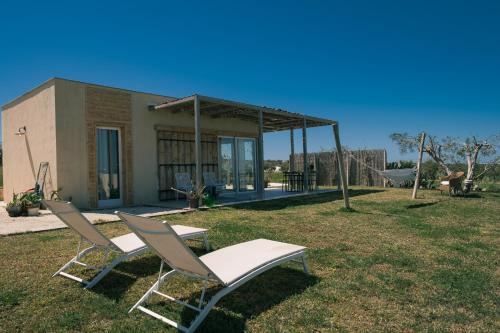 帕基诺NEW Exclusive Lodges, Marzamemi, Noto的院子里有两把椅子和一张桌子