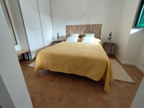 莫托拉Vila Nova Guest House的一间卧室配有一张黄色床罩的床