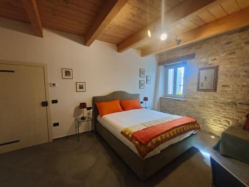 Monte FabbriB&B Locanda Montefabbri的一间卧室设有一张床和砖墙
