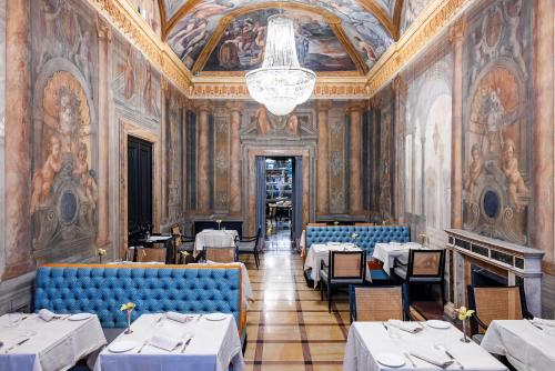 罗马Palazzo Roma - The Leading Hotels of the World的一间带桌椅和吊灯的餐厅