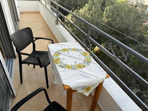 萨兰达Comfort Apartments Promenade的阳台上的桌椅,上面有盘子