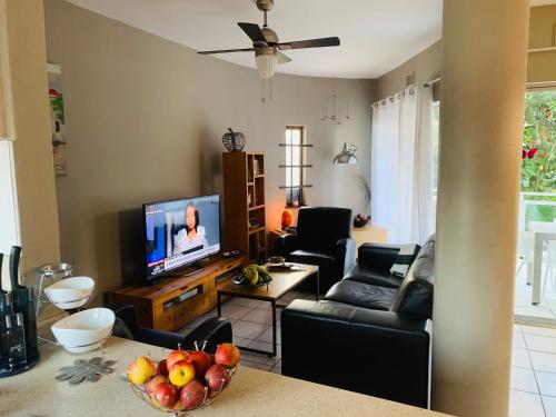 巴利托Beachfront apartment in Ballito! Casablanca的一间带电视和一碗水果的客厅