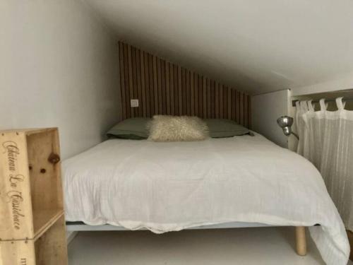 凡尔赛Tiny house avec terrasse的卧室配有白色的床和木制床头板