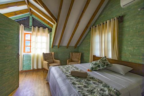 拉迪格岛Ambiance Villa的一间卧室配有一张床、两把椅子和一个窗户