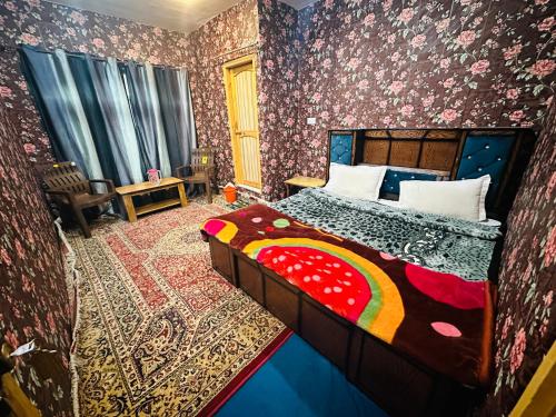 斯利那加HOTEL MERLIN PALACE的卧室配有一张床铺,位于带花卉壁纸的房间
