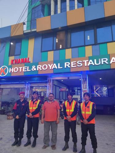 尼泊尔根杰Khanal Hotel的一群身穿橙色背心的人站在一座建筑物前