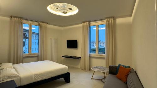 阿雷佐Sette Note Guest House的一间卧室配有一张床、一张沙发和窗户。