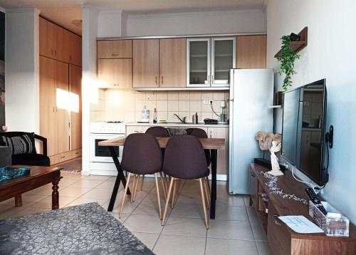 萨莫色雷斯Vaikouzis Houses的厨房配有桌椅和冰箱。