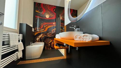 阿雷佐Sette Note Guest House的一间带水槽的浴室和墙上的绘画
