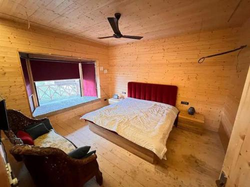 贾姆穆Yellow Pine Luxury Cottage的木制客房内的一间卧室,配有一张床