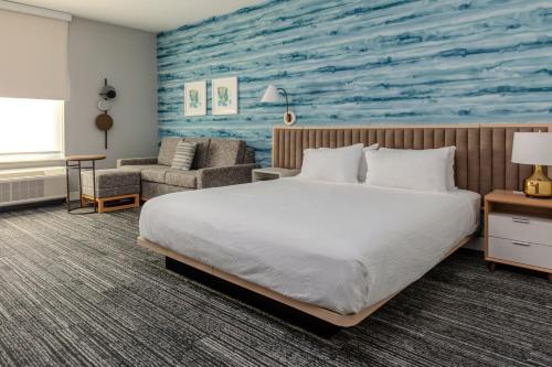 切斯特菲尔德TownePlace Suites by Marriott Chesterfield的一间卧室配有一张床,并画着一幅海洋画