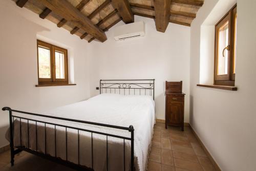 阿夸拉尼亚Casetta in Pietra的一间卧室设有一张床和两个窗户。