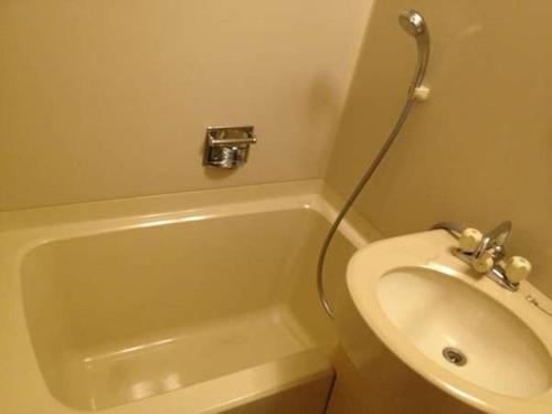 府中市HOTEL LiVEMAX BUDGET Fuchu的一间带水槽、浴缸和卫生间的浴室