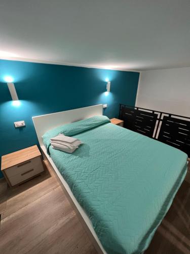 马里利亚诺Da Lello: Luxury Loft strategico的一间卧室配有一张蓝色墙壁的床