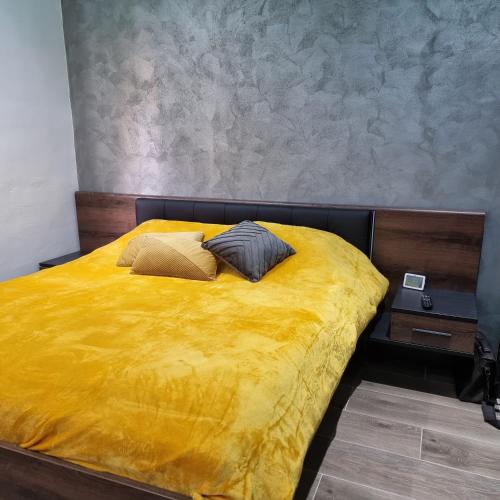 卢加Luqa Premium Rooms的一张黄色的床,上面有两个枕头