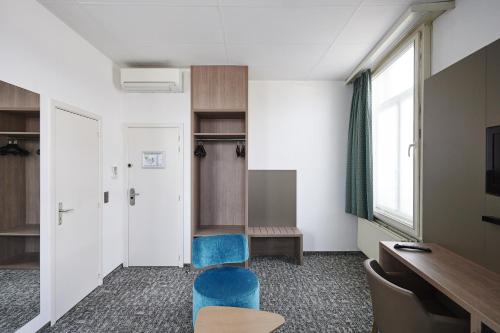 那慕尔佛兰德格兰德酒店的一间配备有蓝色椅子和书桌的等候室