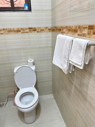 达累斯萨拉姆Rejao Homes的一间带卫生间的浴室和墙上的毛巾